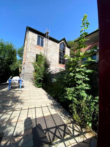 a brick building with a bench in front of it at Villadzor Apart Hotel in Tsaghkadzor