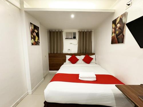a bedroom with a large bed with red pillows at Nest Fort BGC in Manila