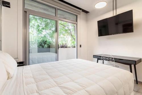 a bedroom with a large white bed and a desk at Mariano Escobedo 48 in Mexico City