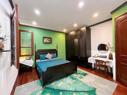una camera con letto e parete verde di Ngáo Home a Hanoi