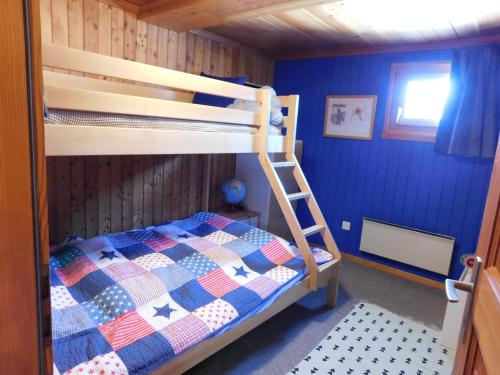 a bedroom with a bunk bed and blue walls at Chalet Bortergade in Bellwald