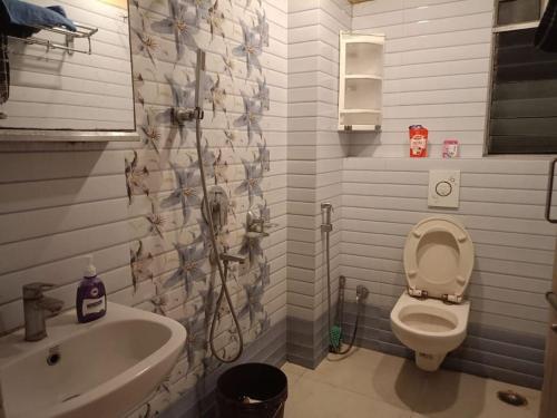 uma casa de banho com um chuveiro, um WC e um lavatório. em Babylon - Luxurious yet Homely Facility em Guwahati