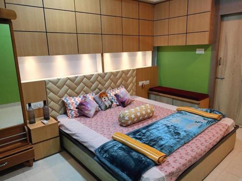 um quarto com uma cama grande e almofadas em Babylon - Luxurious yet Homely Facility em Guwahati