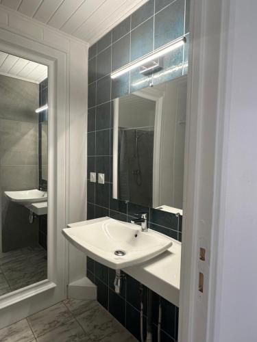 a bathroom with a white sink and a mirror at Suite by Villa Serena - Manapany les bains in Saint-Joseph