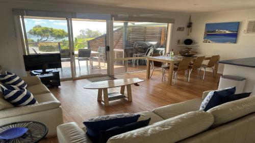Coffin Bay的住宿－小島景觀2號度假屋，客厅配有沙发和桌子