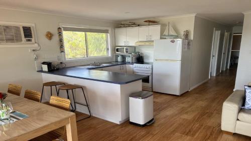 a kitchen with a white refrigerator and a table at Island View 2 in Coffin Bay