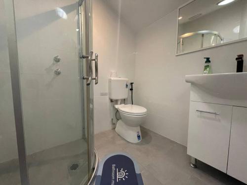a bathroom with a shower and a toilet and a sink at tiny home @ Norwest in Baulkham Hills