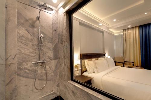 a hotel room with a bed and a shower at Ramada by Wyndham Goa Vagator in Vagator