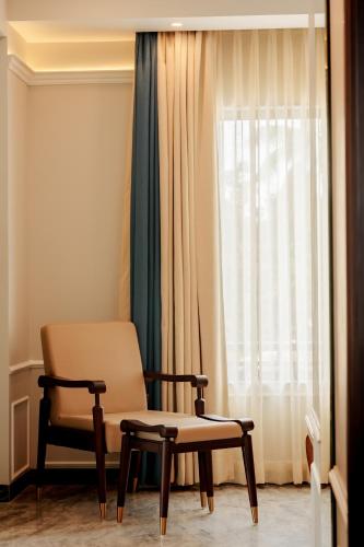 a room with a chair and a window at Ramada by Wyndham Goa Vagator in Vagator