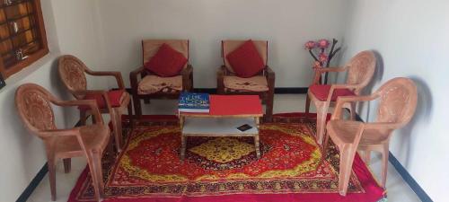 um quarto com cadeiras e uma mesa com uma caixa em Nadiya Kinare em Maheshwar