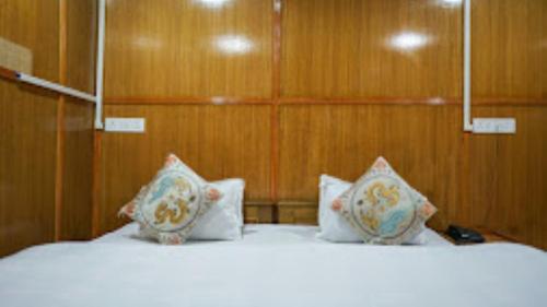 1 dormitorio con 2 camas con sábanas y almohadas blancas en HOTEL TAWANG HOLIDAY Tawang, en Tawang