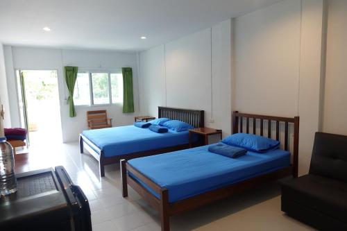 a bedroom with two beds and a couch at Subsavet Village in Ban Tai