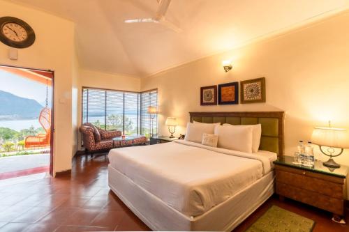 a bedroom with a bed and a view of the ocean at Residency Lake Resort & Spa in Mulshi