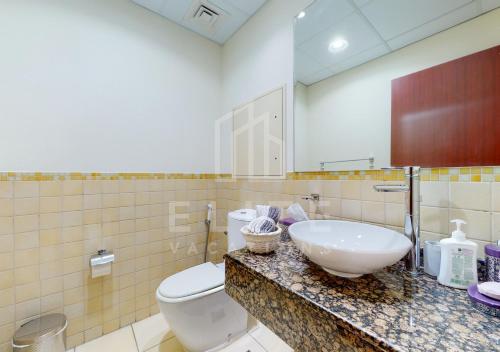 ein Bad mit einem Waschbecken und einem WC in der Unterkunft Beautiful & Cozy 1BR on JBR Beach! in Dubai