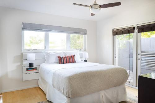 a white bedroom with a large bed and a window at El Mirador by AvantStay Canyon Views Large Pool Outdoor Grill Games Permit4253 in Palm Springs