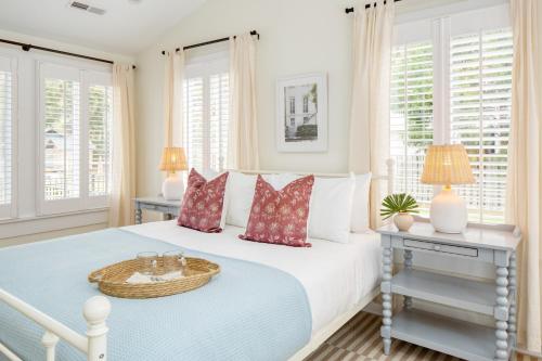- une chambre blanche avec un grand lit et des oreillers dans l'établissement Sawyer by AvantStay Stunning Isle Of Palms Home w Pool, à Isle of Palms