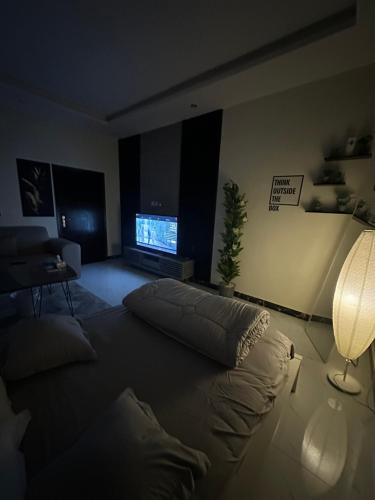 شقة أنيقة في العليا في الرياض: غرفة معيشة فيها سرير وتلفزيون