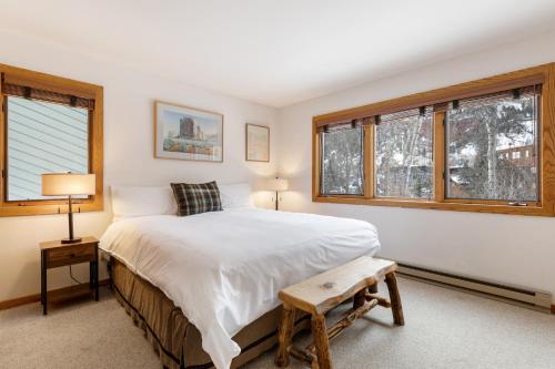 a bedroom with a bed and two windows at Riverside Condos D01 by AvantStay Condo Close To Downtown Town Park Ski Lift 8 in Telluride