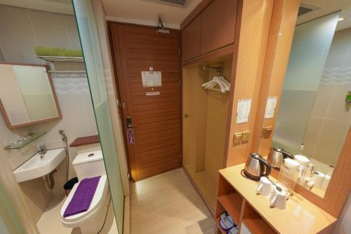 ein Badezimmer mit einem WC, einem Waschbecken und einem Spiegel in der Unterkunft Heef Hotel in Jakarta