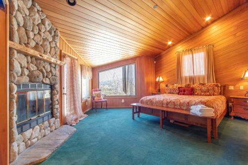 1 dormitorio con cama y pared de piedra en Timberline Lodge by AvantStay Secluded Hill Top Home w Incredible Views, en Big Bear Lake
