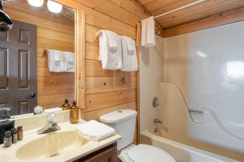 ein Badezimmer mit einem weißen WC und einem Waschbecken in der Unterkunft Fontana by AvantStay Gorgeous Mountain Cabin w Views Hot Tub Game Room in Gatlinburg