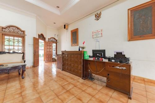a large room with a desk and a wooden floor at RedDoorz Plus at Wisma Kenanga Sukabumi in Sukabumi