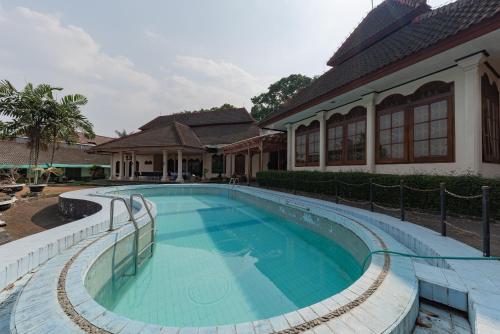 a swimming pool in front of a house at RedDoorz Plus near RSUD R. Syamsudin Bunut Sukabumi in Sukabumi
