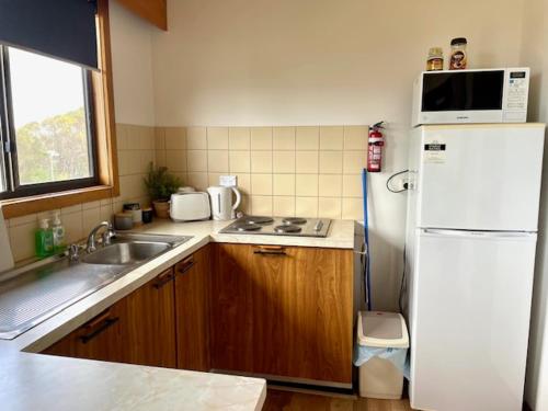 a kitchen with a white refrigerator and a sink at Cooinda Holiday Village Cabins in American River