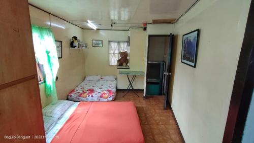 Kochimoto Homestay في باغيو: غرفة صغيرة بسريرين وثلاجة