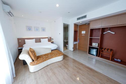 ein Schlafzimmer mit einem Bett und einem Sofa in einem Zimmer in der Unterkunft Heef Hotel in Jakarta