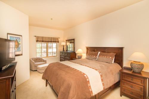 a bedroom with a large bed and a television at Westermere 311 - 2 by AvantStay Just Steps From Ski Area w Great Views in Telluride