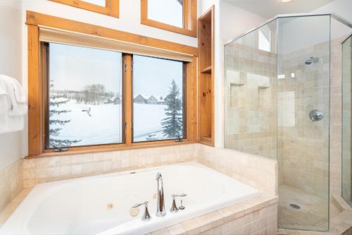 ein Bad mit einer Badewanne, einer Dusche und einem Fenster in der Unterkunft Adams Ranch Retreat by AvantStay Free Shuttle 2 Mountain Village Telluride Ski Resort in Telluride