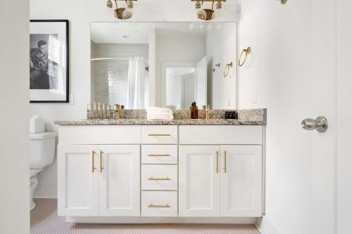 Baño blanco con lavabo y espejo en Hart Suite 11 by AvantStay Gorgeous Town House w Modern Amenities in Nashville en Nashville