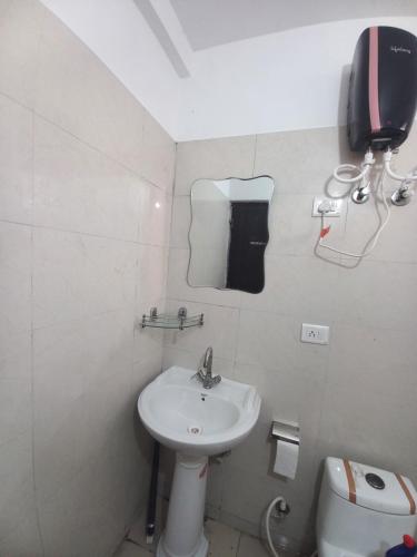 a white bathroom with a sink and a toilet at Paradise Homes in Agra
