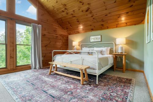 ein Schlafzimmer mit einem Bett und einer Holzdecke in der Unterkunft Hollows Haven by AvantStay Hot Tub Sauna Balcony and Tree Top Views in Gatlinburg