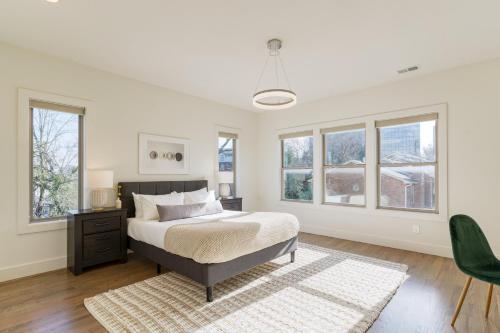 a white bedroom with a bed and windows at Springsteen by AvantStay Stylish Townhouse in Nashville in Nashville