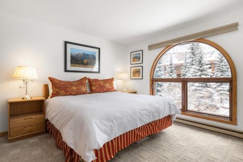 een slaapkamer met een bed en een groot raam bij Riverside Condos A103 by AvantStay Condo Close To Downtown Town Park Ski Lift 8 in Telluride