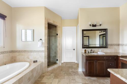 y baño con bañera, ducha y lavamanos. en Palazzo Del Sol By AvantStay Breathtaking Home w Mountain Views Hot Tub, en Temecula