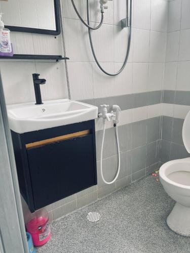 La salle de bains est pourvue d'un lavabo et d'une douche. dans l'établissement AK Greenrise Meru, à Ipoh