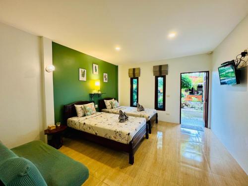 a bedroom with two beds and a green wall at AJ Paradise Resort Aonang Krabi in Ao Nang Beach
