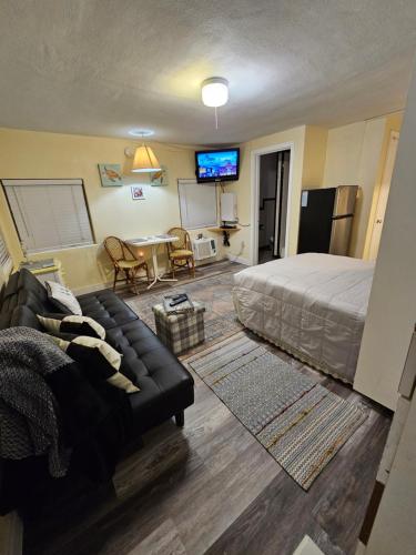 a bedroom with a bed and a couch and a table at Mandaly Bay Efficiency Comfort in Clearwater Beach