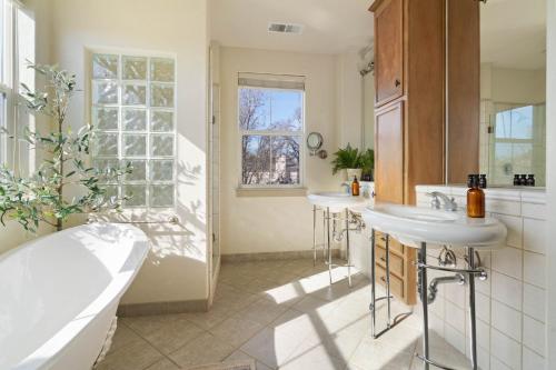 a bathroom with two sinks and a tub at Fiano by AvantStay Centrally Located Haven w Stunning Courtyard Pool Table in Windsor