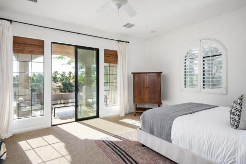 sypialnia z łóżkiem i przesuwnymi szklanymi drzwiami w obiekcie Villa Verbena by AvantStay Expansive Estate w B-ball Court PoolSpa Entertainers Yard w Bermuda Dunes