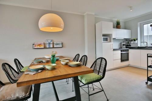 uma mesa de jantar com cadeiras e uma cozinha em City Marina, CM16b em Cuxhaven
