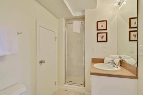 a white bathroom with a sink and a shower at Coral Villa by AvantStay Close 2 DT Key West Shared Pool Month Long Stays Only in Stock Island