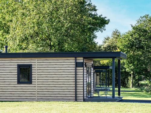 Un pequeño cobertizo con techo negro en Friesensee Camping und Ferienpark, en Wittmund