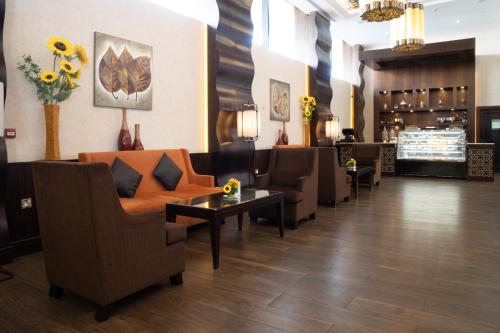 a waiting room with chairs and a couch and a table at Danat Al Ain Resort in Al Ain