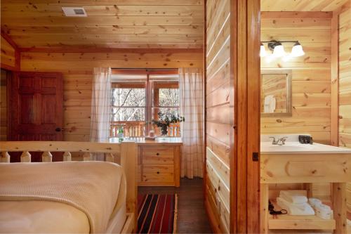 een slaapkamer met een bed en een wastafel bij Haywood by AvantStay Mountain Living Dream w Movie Theatre Indoor Pool Hot Tub and Views in Sevierville