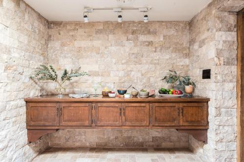 a stone wall with a wooden counter with fruits on it at La Casona by AvantStay Gorgeous Spanish Style Oasis w Historic Charm Pool in Phoenix