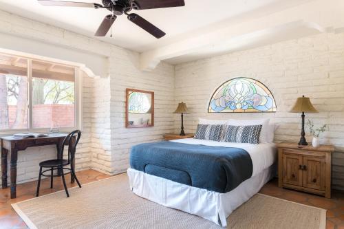 a bedroom with a bed and a desk and a window at La Casona by AvantStay Gorgeous Spanish Style Oasis w Historic Charm Pool in Phoenix